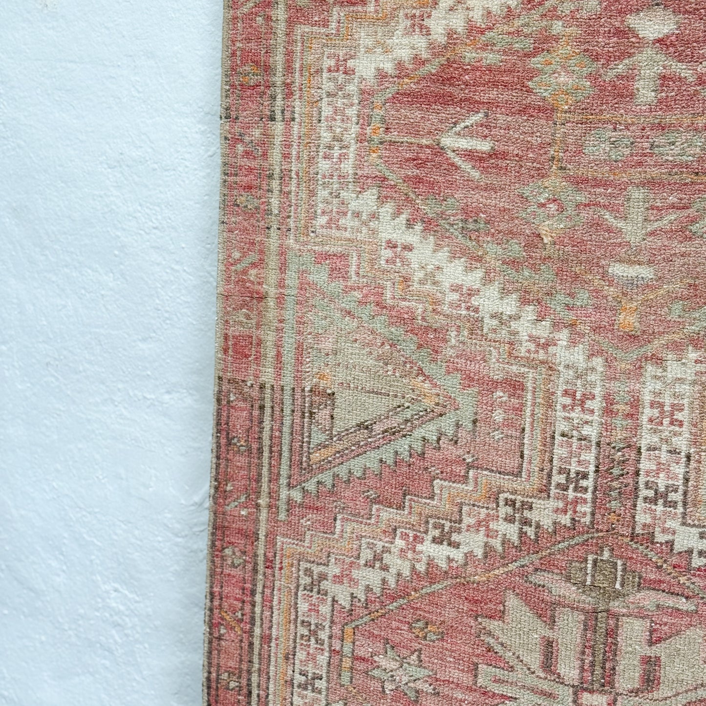 Close-up of a patterned rug with geometric design on a light blue background