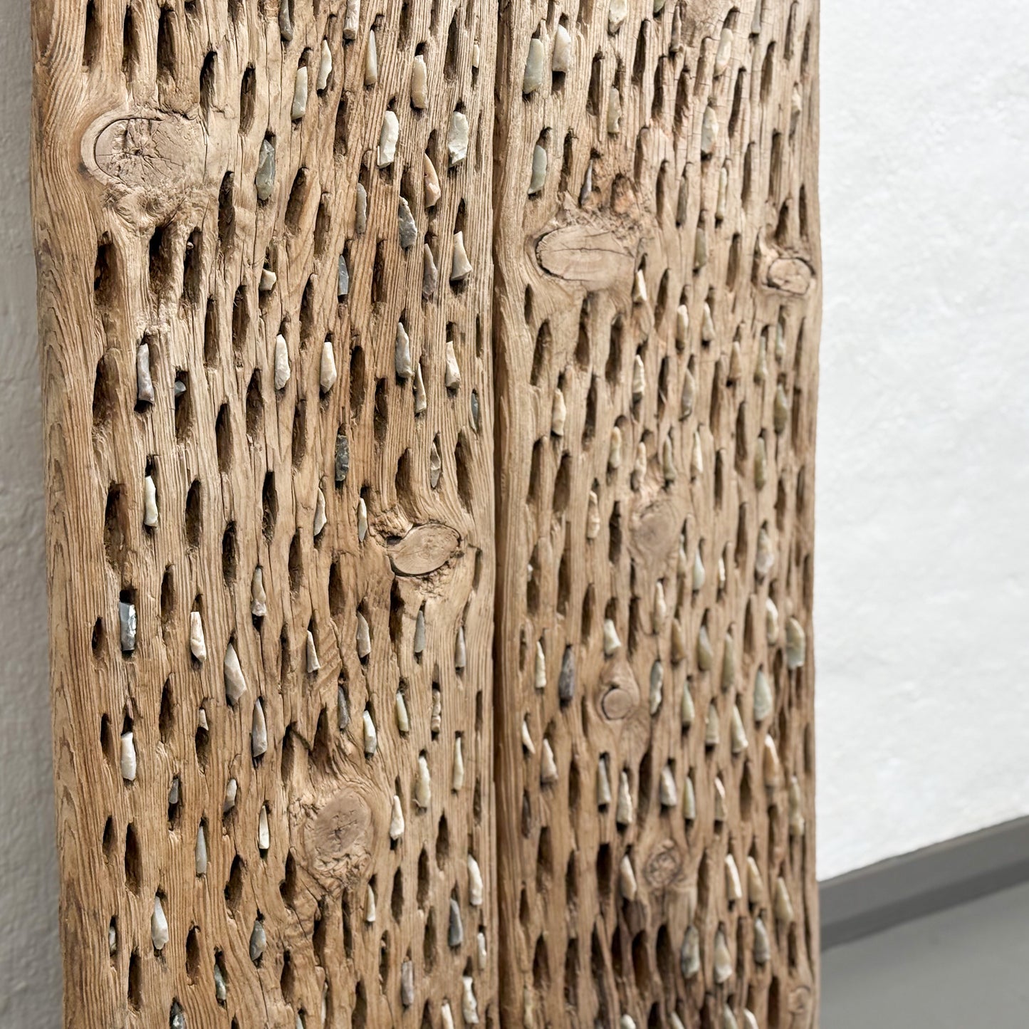 Wooden panel with intricate carvings on a plain background