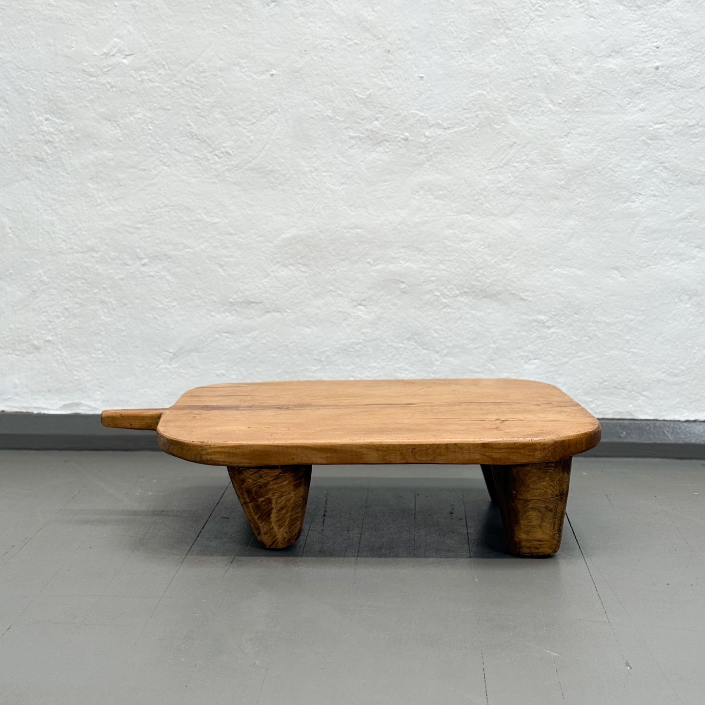 Wooden bench against a plain white wall
