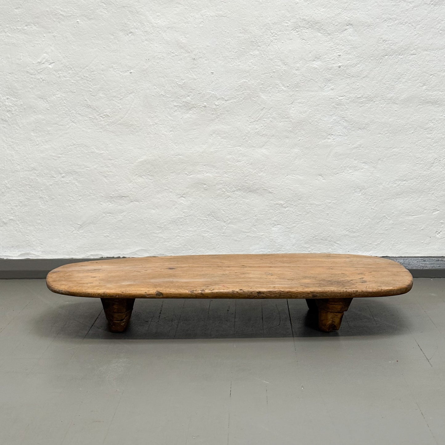 Wooden bench against a plain white wall