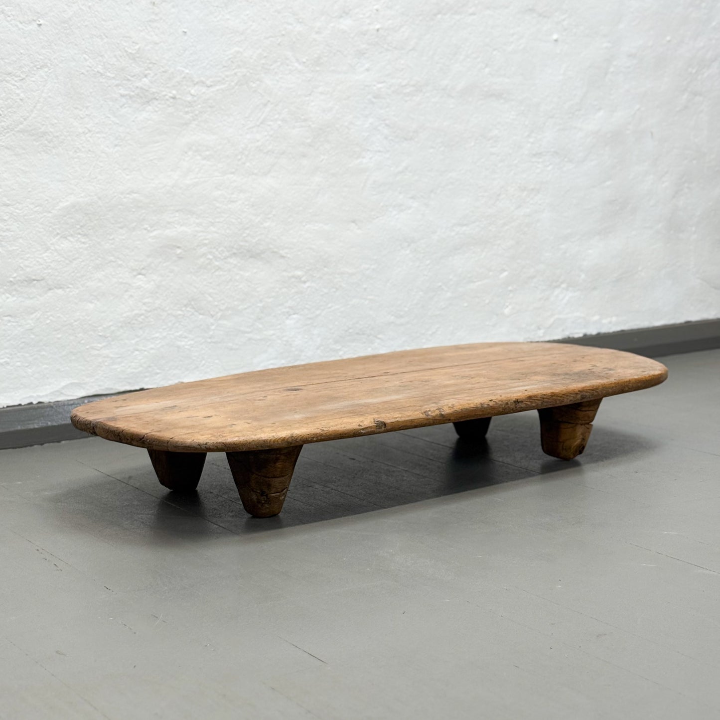 Wooden bench against a plain wall