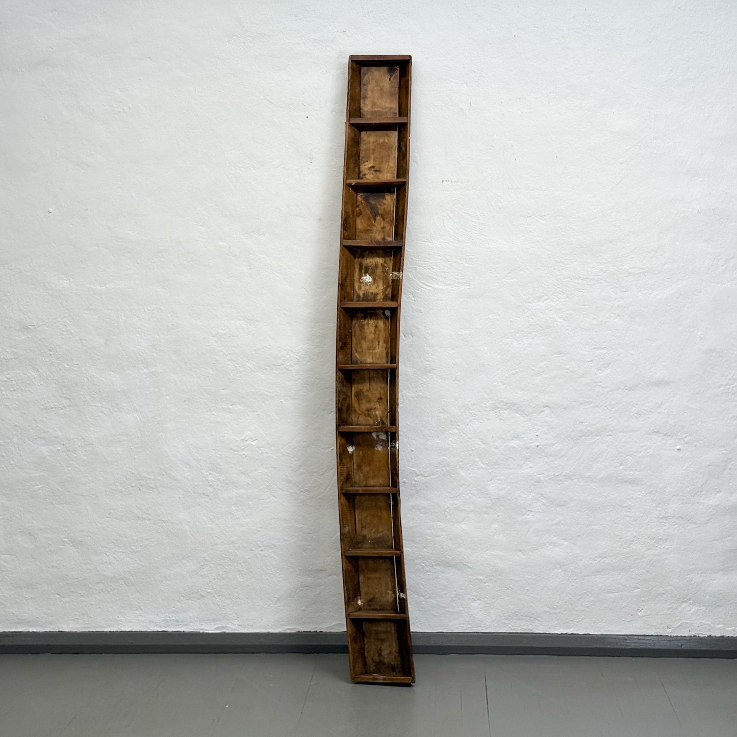 Tall wooden crate against a white wall