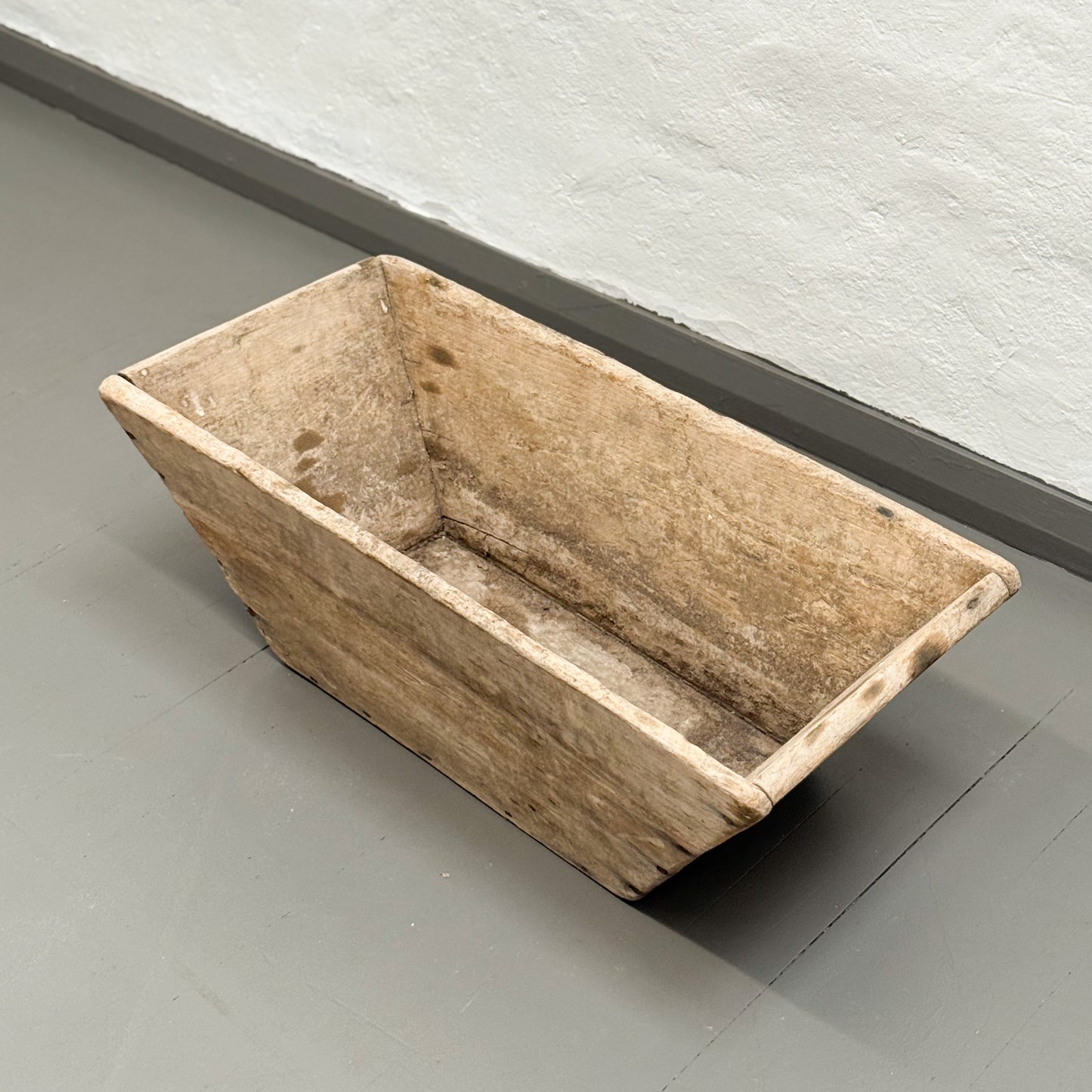 Rectangular wooden trough on a gray floor